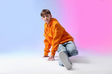 Renkli arka planda dans eden şık elbiseli çocuk.