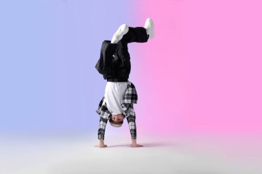 Renkli arka planda dans eden şık elbiseli çocuk.