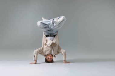 Açık gri arka planda dans eden şık elbiseli çocuk, metin için yer var.