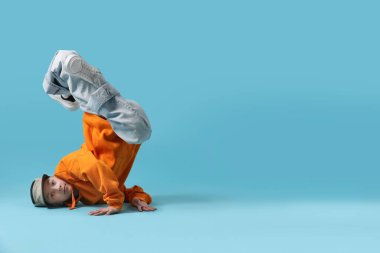 Açık mavi arka planda dans eden şık elbiseli çocuk, metin için yer var.