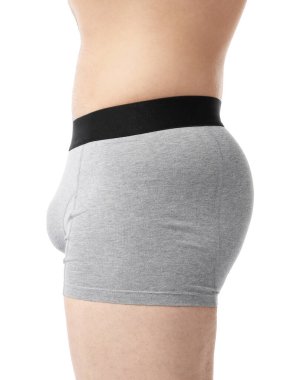 Beyaz arka planda açık gri iç çamaşırlı genç adam, yakın plan.