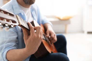 Evde gitar çalan adam, eline odaklan. Metin için boşluk