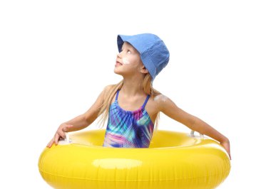 Cildinde güneş kremi ve beyaz arka planda şişme yüzük olan gülümseyen küçük bir kız.