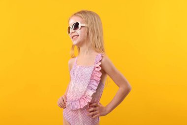 Yüzünde güneş kremi olan gülümseyen küçük bir kız.