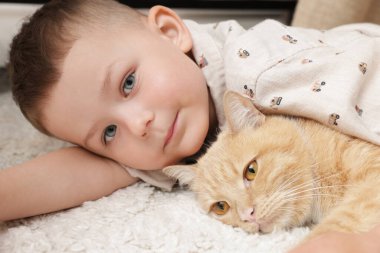 Evinde kızıl kedisi olan küçük bir çocuk