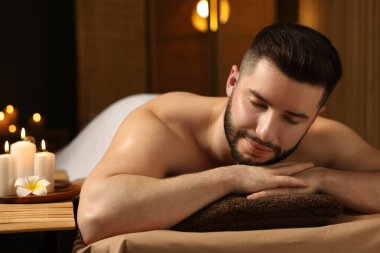 Güzellik salonunda masaj masasında yatan yakışıklı adam.