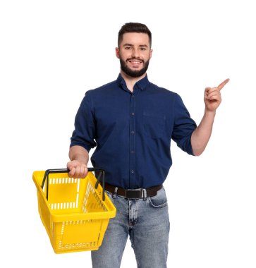 Boş alışveriş sepeti olan bir adam beyaz arka plandaki bir şeyi işaret ediyor.