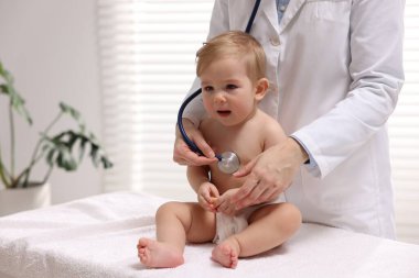Pediyatrist klinikte küçük şirin bir bebeği muayene ediyor.