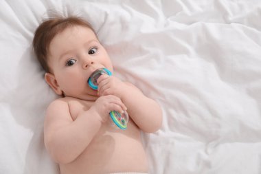 Evdeki yatağında çıngıraklı oyuncağı olan sevimli bir bebek. Metin için boşluk