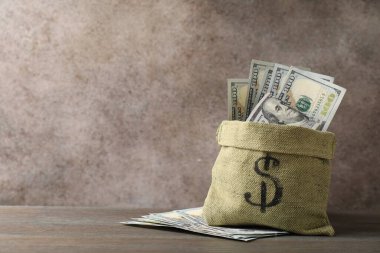 Tahta masanın üzerinde dolar banknotları olan çanta, metin için yer