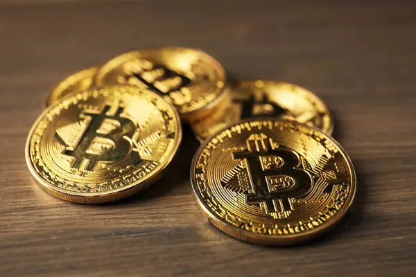 Kripto para birimi. Ahşap masada bir sürü bitcoin var, yakın plan.