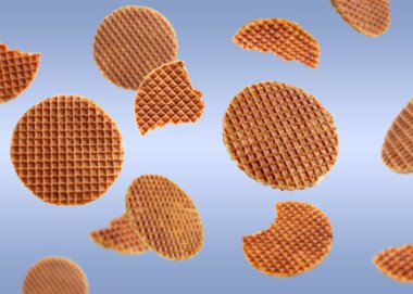 Açık mavi gradyan üzerinde uçan lezzetli Hollanda waffleları (stroopwafels)