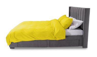 Beyaz arka planda güzel çarşaflarla yapılmış bir yatak.