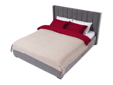 Beyaz arka planda güzel çarşaflarla yapılmış bir yatak.