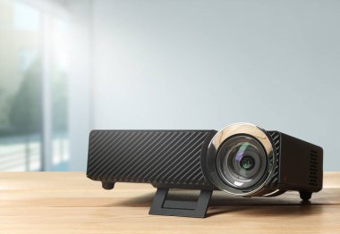 Odanın ahşap masasında modern video projektörü
