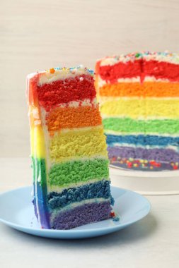 Lezzetli bir parça gökkuşağı pastası beyaz masada, yakın plan.