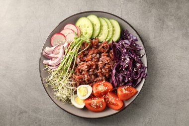 Gri masada kahverengi pirinçli lezzetli bir salata.