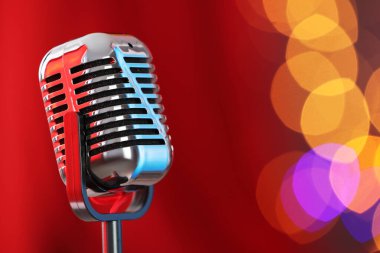 Kırmızı perdeye karşı bir klasik mikrofon, mesaj için yer. Bokeh etkisi