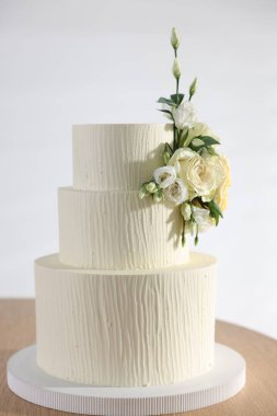 İçerideki ahşap masada çiçek desenli nefis düğün pastası.