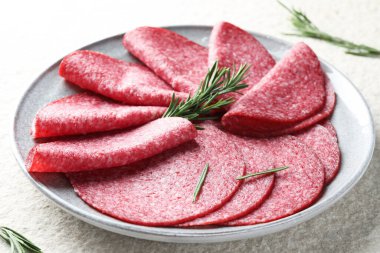 Beyaz desenli masada servis edilen biberiyeli leziz sosis dilimleri.