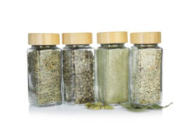 Beyaz kavanozlardaki farklı aromatik baharatlar.