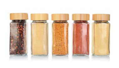 Beyaz kavanozlardaki farklı aromatik baharatlar.