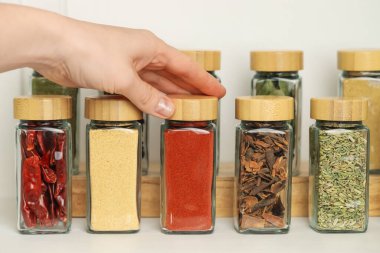 Kapalı mekanda kırmızı biber tozlu kavanoz alan kadın, yakın plan.