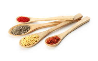 Beyaz kaşıklardaki farklı aromatik baharatlar.