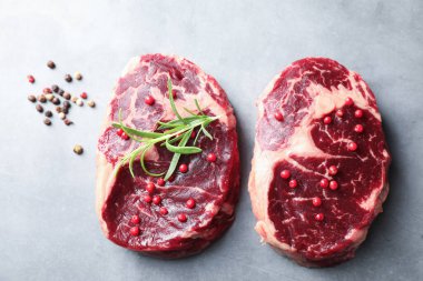 Çiğ et parçaları ve baharatlar gri dokulu masa üzerinde, düz yatıyordu.