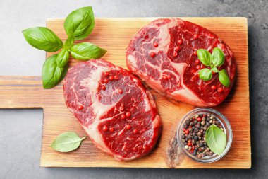 Gri masa üzerinde çiğ et ve baharat parçaları.