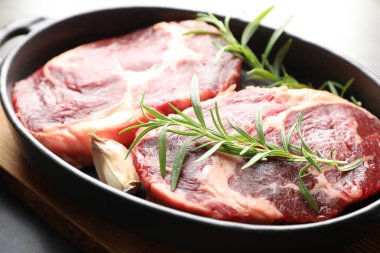 Yemek masasında çiğ et ve baharat parçaları, yakın plan.