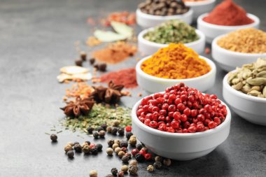 Gri masada farklı aromatik baharatlar, yakın plan.