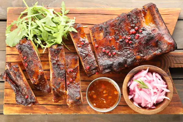 Lezzetli pirzola, sos, roka ve soğan ahşap masa, üst manzara.