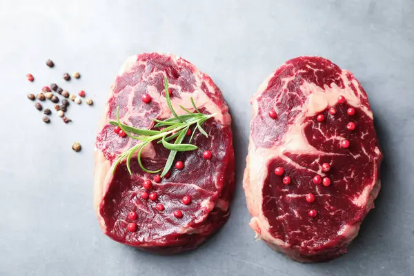 Çiğ et parçaları ve baharatlar gri dokulu masa üzerinde, düz yatıyordu.