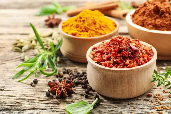 Ahşap masada farklı aromatik baharatlar, yakın plan.