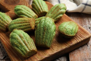 Lezzetli Matcha Madeleine kekleri ahşap masada, yakın plan.