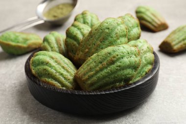 Lezzetli madelaine kekleri ve kibrit tozu ışık masasında, yakın plan.