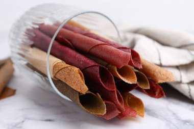 Lezzetli meyveler beyaz mermer masada yuvarlanıyor, yakın plan.