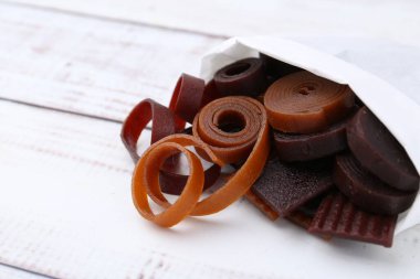 Lezzetli meyve derisi kağıt poşet içinde beyaz ahşap masa üzerinde, yakın plan. Metin için boşluk