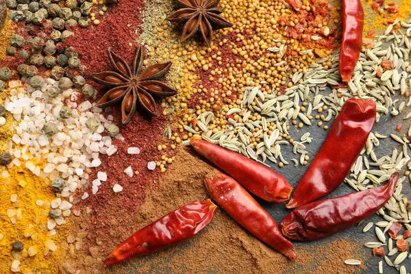 Gri masada farklı aromatik baharatlar, üst görünüm.