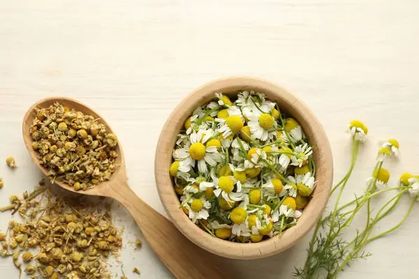 Kuru ve taze papatya çiçekleri açık ahşap masada, düz yatıyordu.