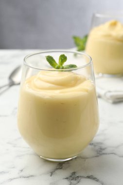 Beyaz mermer masada naneli vanilyalı puding, yakın plan.