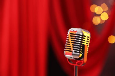 Kırmızı perdeye karşı bir klasik mikrofon, mesaj için yer. Bokeh etkisi