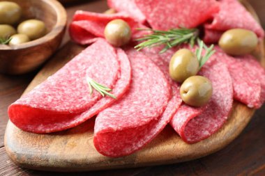 Ahşap masada servis edilen zeytinli ve biberiyeli lezzetli sosisler.