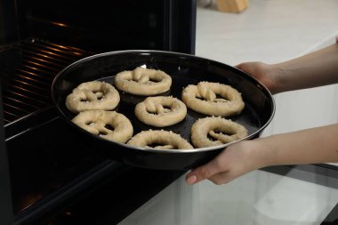 Pişmemiş krakerlerle fırına yemek koyan kadın, yakın plan.