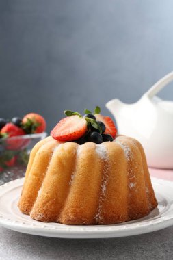 Açık gri masada pudra şekeri ve böğürtlenli Lezzetli kek, yakın plan. Metin için boşluk