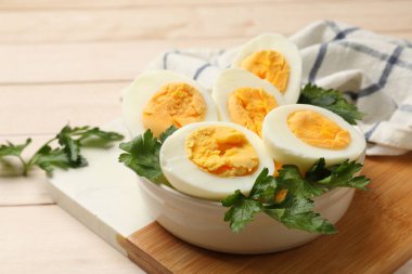 Ahşap masada haşlanmış yumurta ve maydanoz, yakın plan.