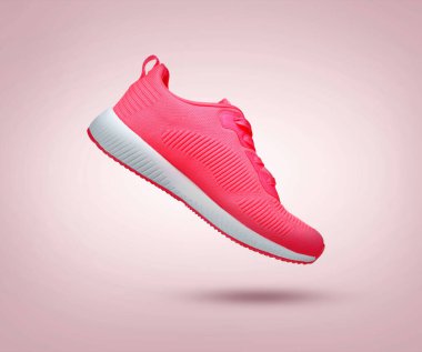 Tozlu pembe eğimli arka planda şık bir spor ayakkabı.