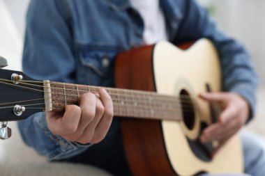 Sandalyede gitar çalan adam, yakın plan.