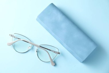 Açık mavi arka planda şık gözlüklü çanta, düz uzanma